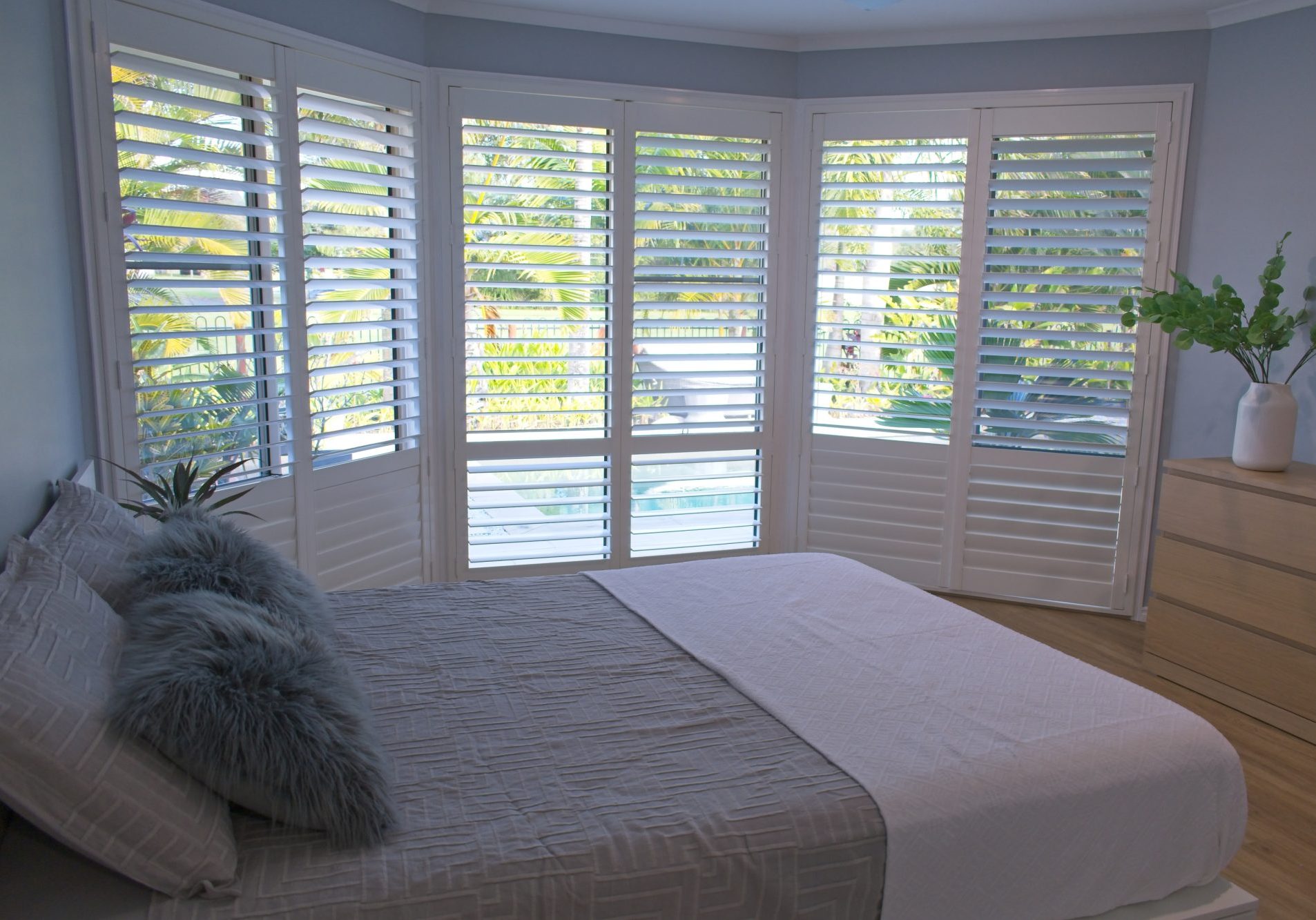 Luxury white plantation shutters in bedroom